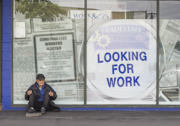 Een man bedelt terwijl hij voor een uitzendbureau zit. De foto werd genomen in Nieuw-Zeeland. In Vlaanderen zijn er zo'n 18.000 werkzoekenden van wie de VDAB denkt ze geen kans maken op een job in de reguliere economie.