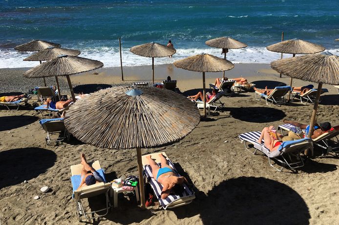 Toeristen genieten van zee en strand in Griekenland.