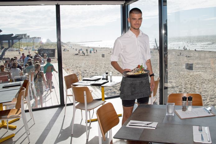 Daan Martlé presenteert de kabeljauw aan tafel. Bij Moio Beach is het strandgevoel altijd dichtbij, ook als je binnen dineert.