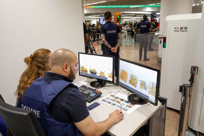 Douanepersoneel in Brussel controleert de bagage. Marcel (niet op de foto) zorgt dat deze mensen met de nieuwste apparatuur kunnen werken om snel analyses te doen.