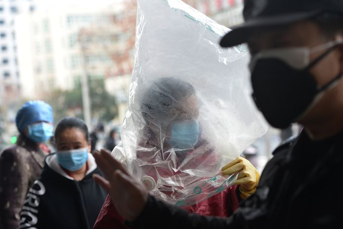 Bewoners in Wuhan doen er alles aan om een besmetting met Covid-2019 te voorkomen. Zoals deze vrouw, die een mondmasker draagt én een plastic zak over het hoofd trok.