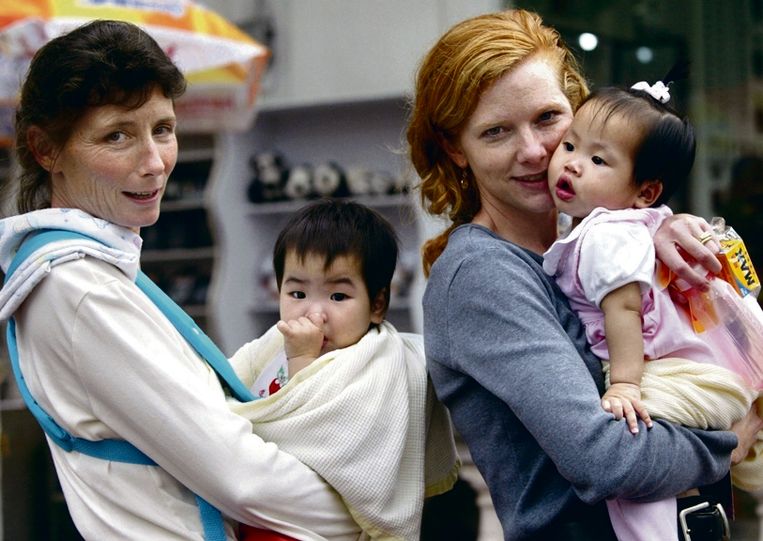 April 2003: Amerikaanse vrouwen wandelen door een park met hun net geadopteerde Chinese baby's in Guangzhou.  Beeld REUTERS