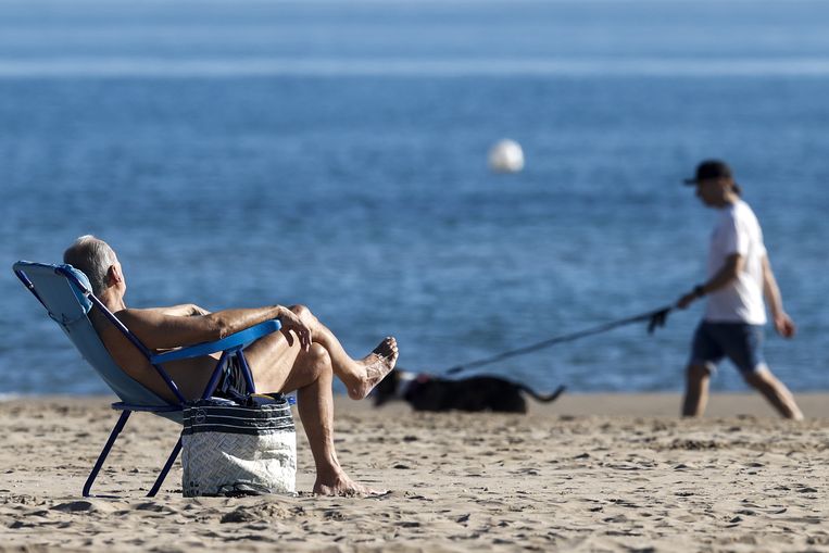 Een man geniet van de zon in het Spaanse Valencia op 24 december. Beeld ANP / EPA