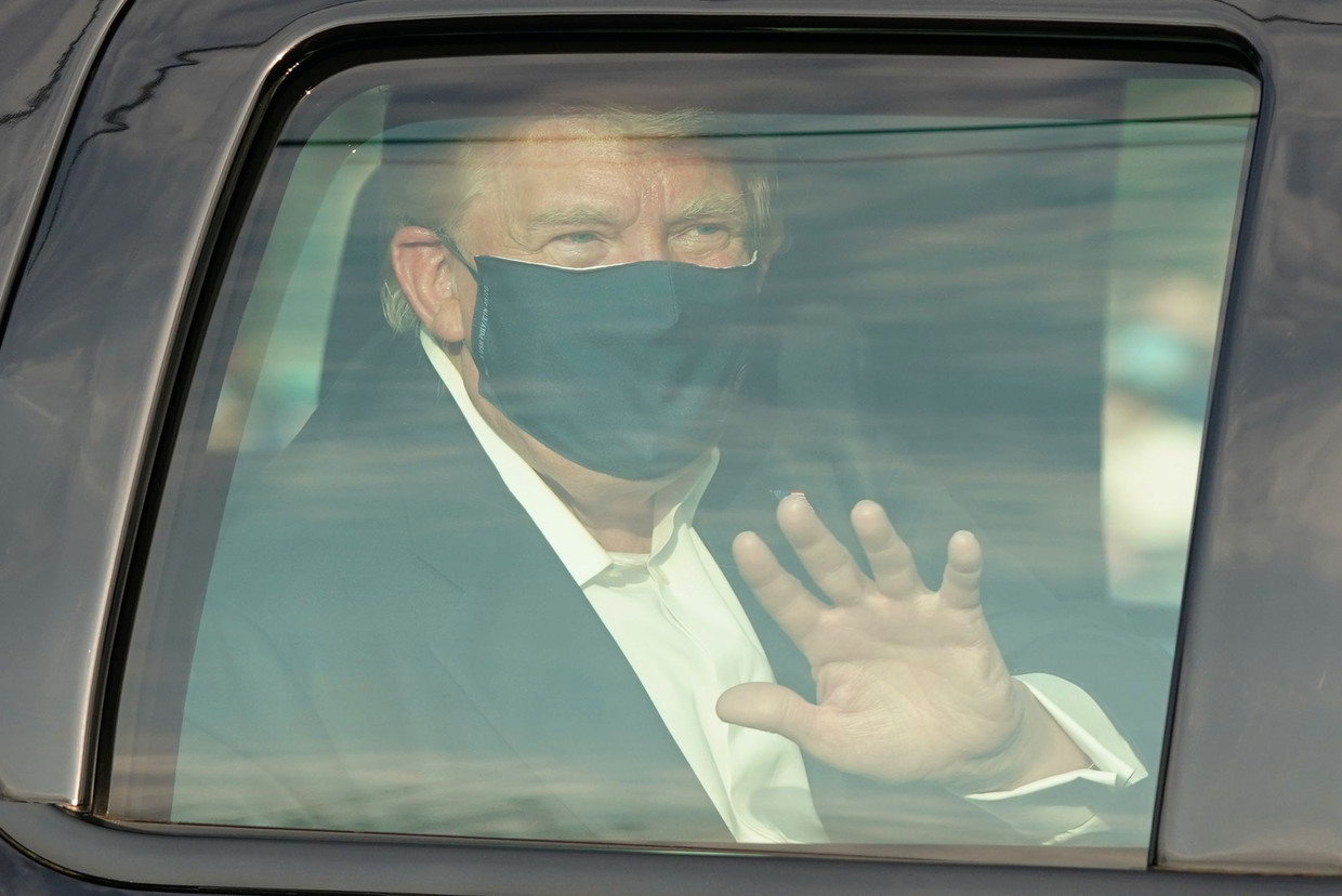 De Amerikaanse president Trump rijdt langs aanhangers bij het Walter Reed Medical Center in Bethesda in de staat Maryland, na daar te zijn hersteld van een coronabesmetting.  Beeld AFP