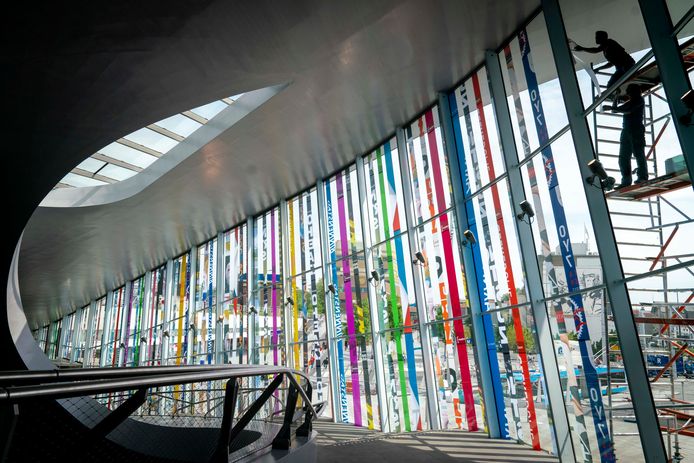 De banieren voor State of Fashion worden bevestigd aan de glazen gevel van het Arnhemse stationsgebouw.