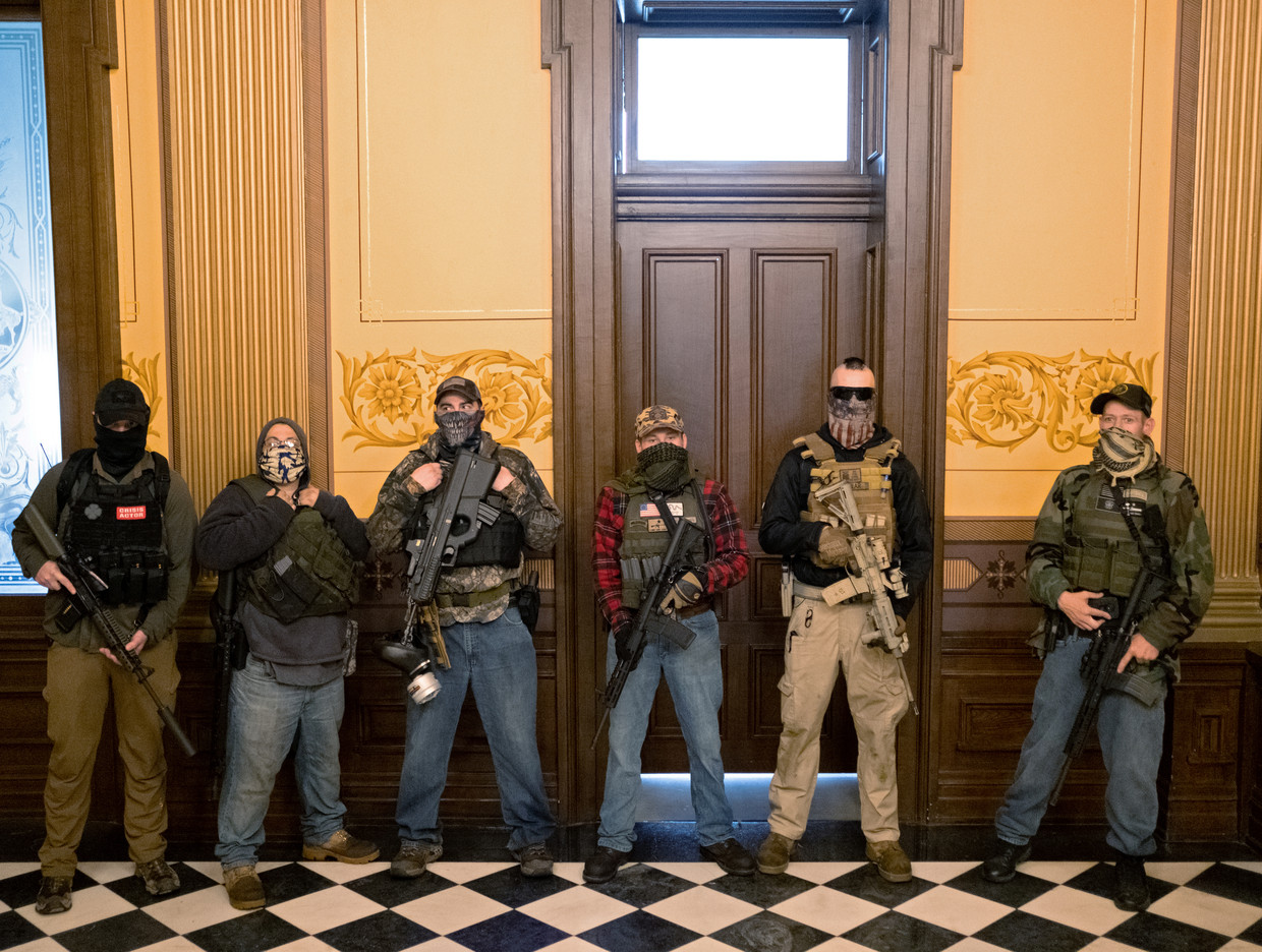 Leden van een paramilitaire groep blokkeren eind april de deur van het parlementsgebouw in Michigan, nadat die staat verregaande coronabeperkingen afkondigde.