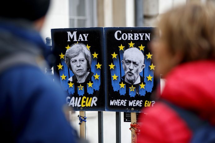 Posters met daarop Theresa May (links) en Jeremy Corbyn.