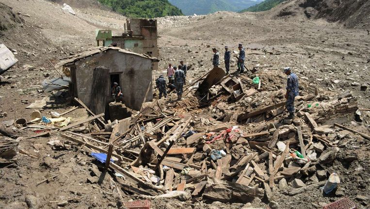 Nepalese reddingswerkers onderzoeken het rampgebied. Beeld afp