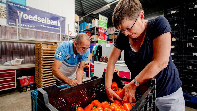 Vrijwilligers sorteren kilo's paprika's bij de voedselbank. Beeld ANP
