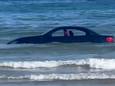 Omstanders filmen de BMW in het water.