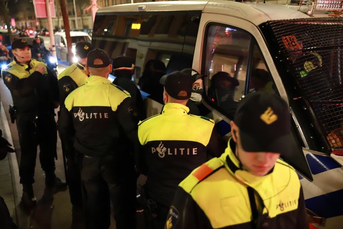 Meerdere relschoppers zijn geboeid in een politiebusje gestopt.