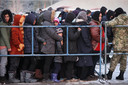 Migranten bij een checkpoint aan de grens tussen Polen en Belarus