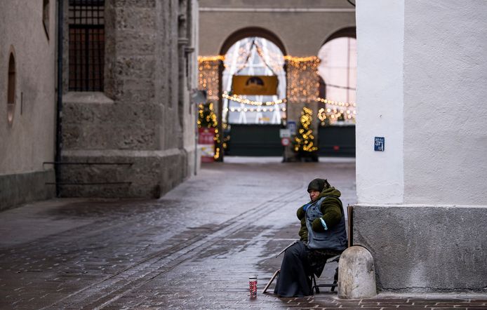Een eenzame bedelaar op straat in Salzburg.