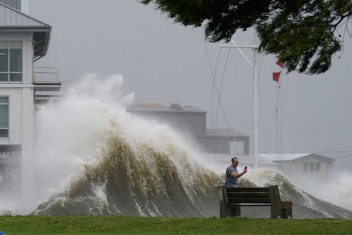 Een man neemt een foto aan de oever van Lake Pontchartrain ten noorden van New Orleans.