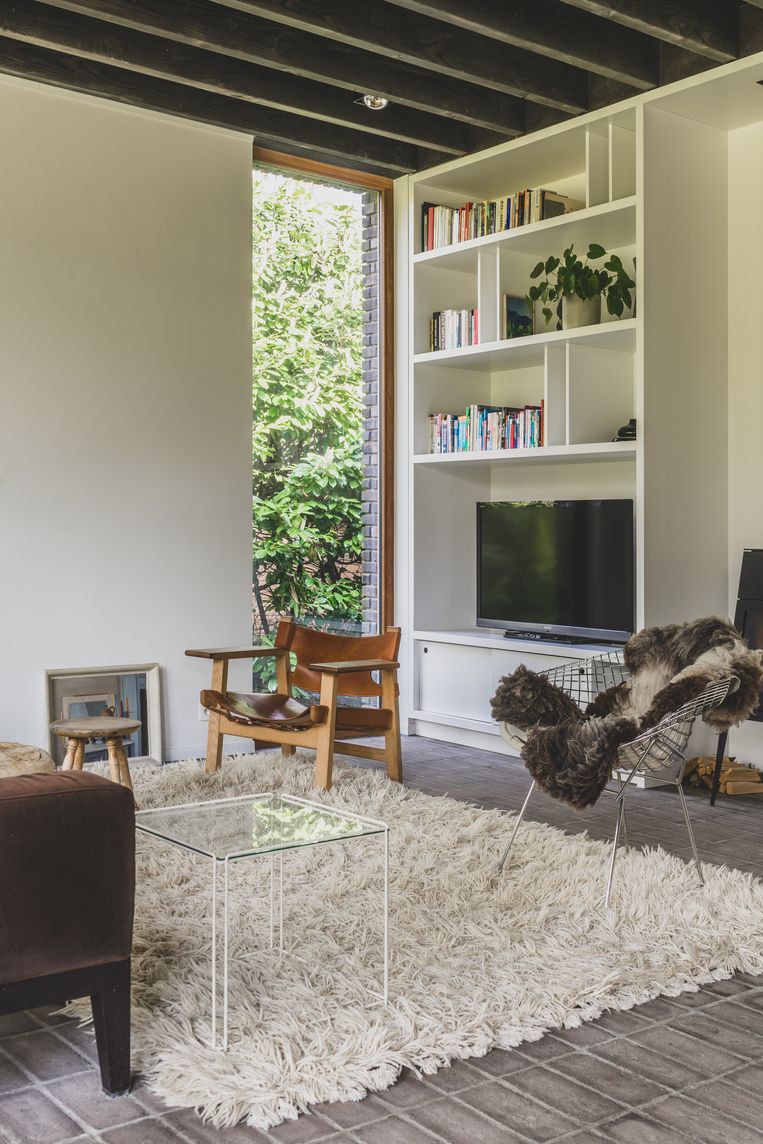 Typisch bij een woning van Eddy François is de bakstenen vloer. Met een wollig tapijt maak je die extra warm. De meubels zijn vintage.
 Beeld Hannelore Veelaert