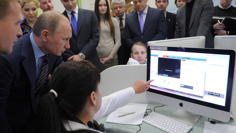 Poetin (l) in het verkiezingscentrum in Moskou. Beeld AFP
