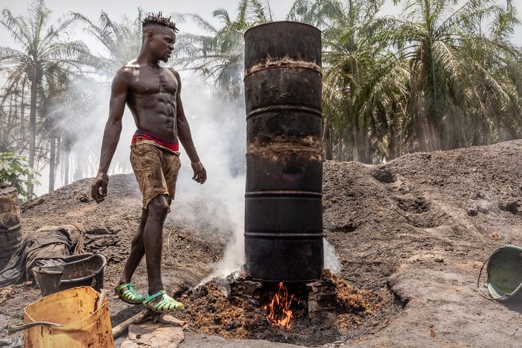 Een jonge man maakt palmolie uit palmpitten geoogst uit zijn eigen palmboomgaard. Beeld Sven Torfinn