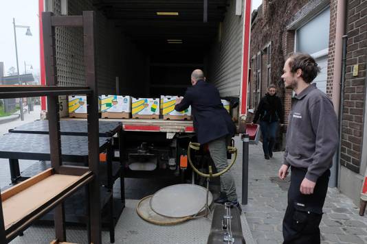 De eerste vrachtwagen wordt gevuld met kartonnen dozen.