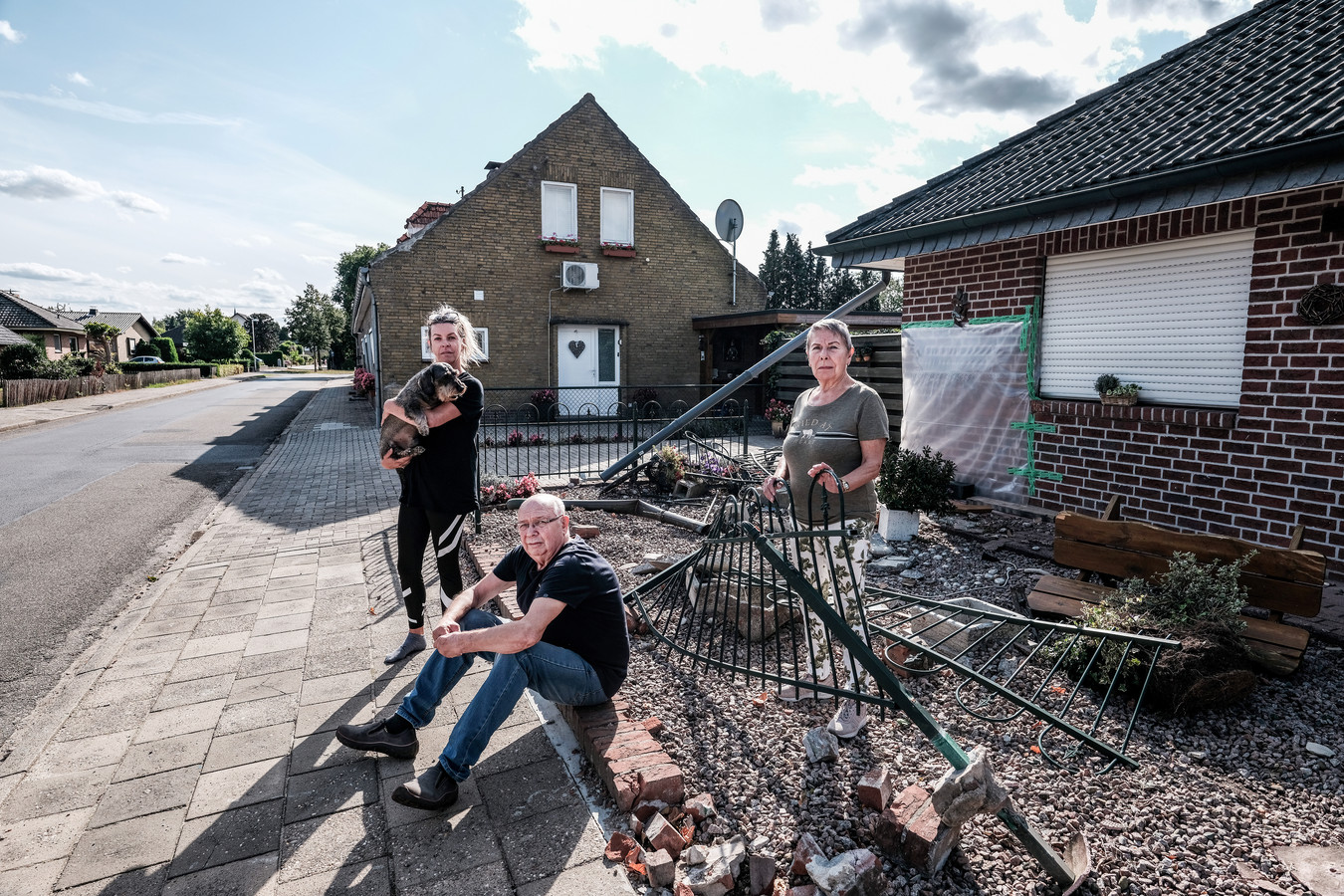 De familie Buil in hun vernielde tuin, waar een aanhanger crashte.  Foto : Jan Ruland van den Brink