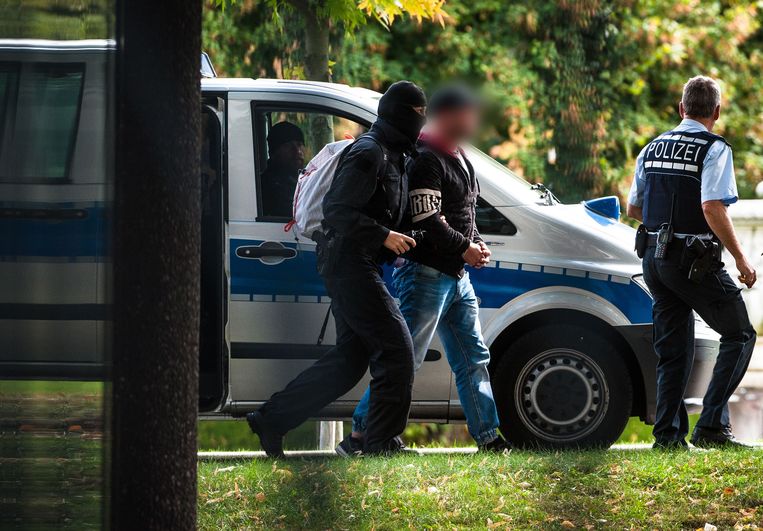 Een van de verdachte rechts-extremisten wordt afgevoerd naar het hooggerechtshof in Karlsruhe. Beeld AFP