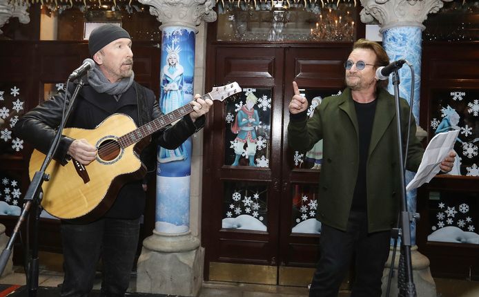 The Edge (links) en Bono tijdens het optreden voor daklozen op Grafton Street in Dublin.