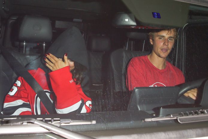 Selena verbergt haar gezicht naast Justin.