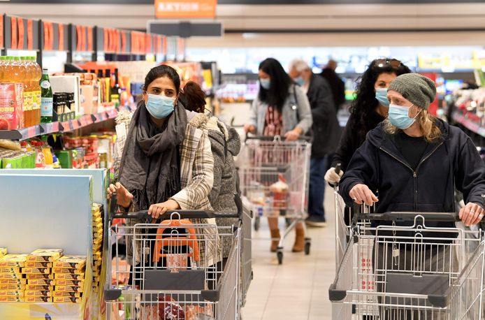 Klanten met mondmaskers in een supermarkt in Wenen vandaag. Vanaf nu is het verplicht in Oostenrijk om in supermarkten een masker te dragen.