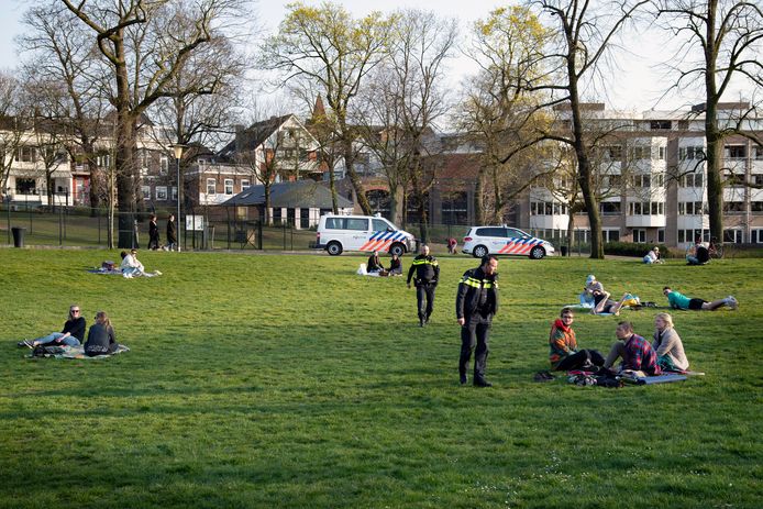Politie-agenten delen aan het eind van de vrijdagmiddag bonnen uit in het Kronenburgerpark. Iedereen die zich niet aan de coronavoorschriften houdt, gaat op de bon.