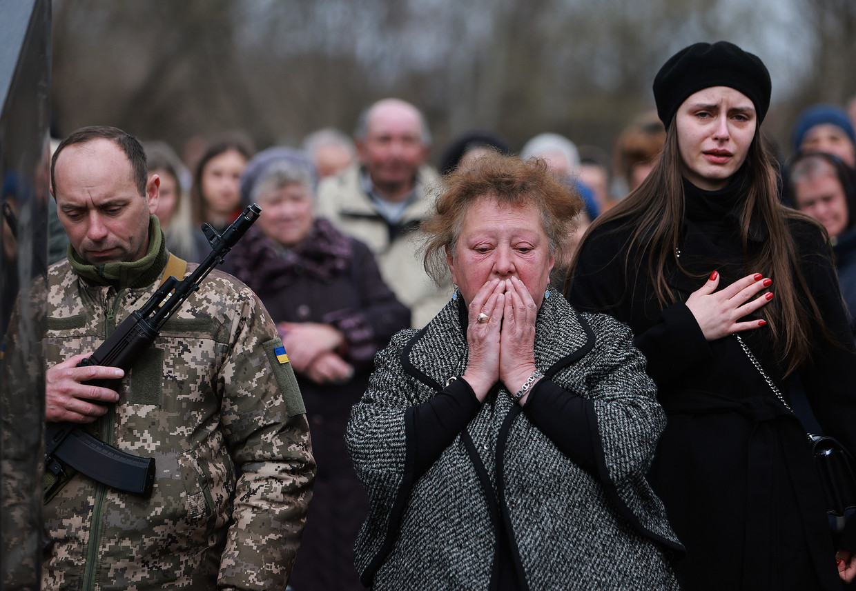 De familie van een Oekraïense soldaat rouwt tijdens zijn begrafenis. Beeld Getty Images