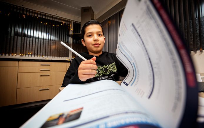 Kim Hofstede en haar zoon Jamal (12). Jamal zit aan de keukentafel en moeder helpt met overhoren.