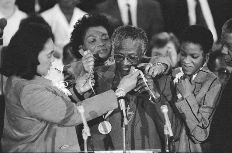 

Oud-aartsbisschop Desmond Tutu ontvangt de Martin Luther King Jr. Peace Prize van Coretta Scott King (links) en Christine King Farris, de dochter van King (midden) in 1986. Tutu's dochter Mpho, rechts, aanschouwt de ceremonie. Beeld AP