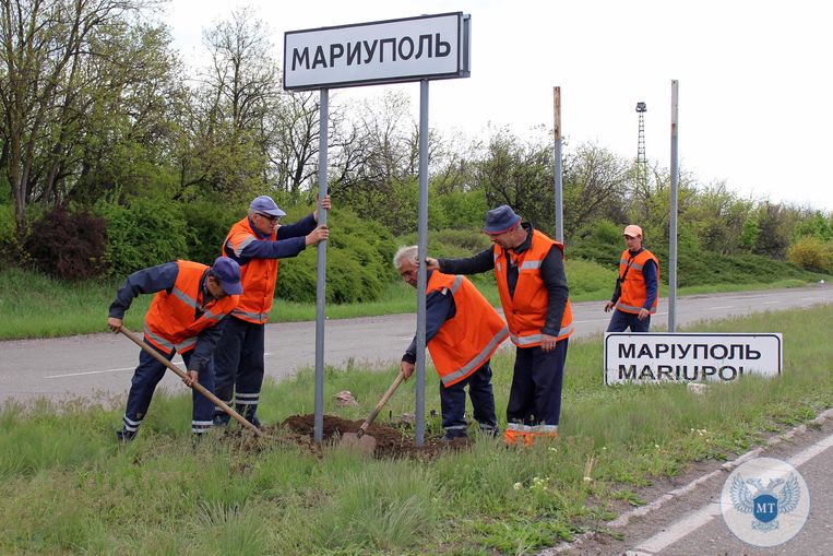 Oekraïense be­weg­wij­ze­ring wordt vervangen door borden in het Russisch langs de weg naar Marioepol. Beeld AFP