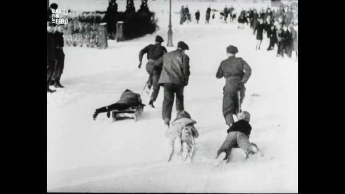 Canadese soldaten trekken kinderen uit Hatert voort op hun slee, tijdens een wedstrijd in de winter van 1944-1945.