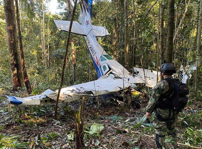 Een soldaat naast het wrak van het neergestorte vliegtuig. De kinderen overleefden de vliegtuigcrash en brachten veertig dagen door in de jungle.
