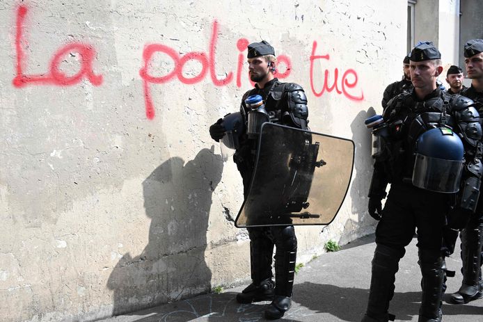 Polizia antisommossa a Parigi, accanto alla lettura dei graffiti "La polizia uccide".