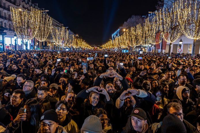 Una grande folla si prepara per il tradizionale spettacolo di luci e fuochi d'artificio vicino all'Arco di Trionfo sugli Champs-Élysées a Parigi.