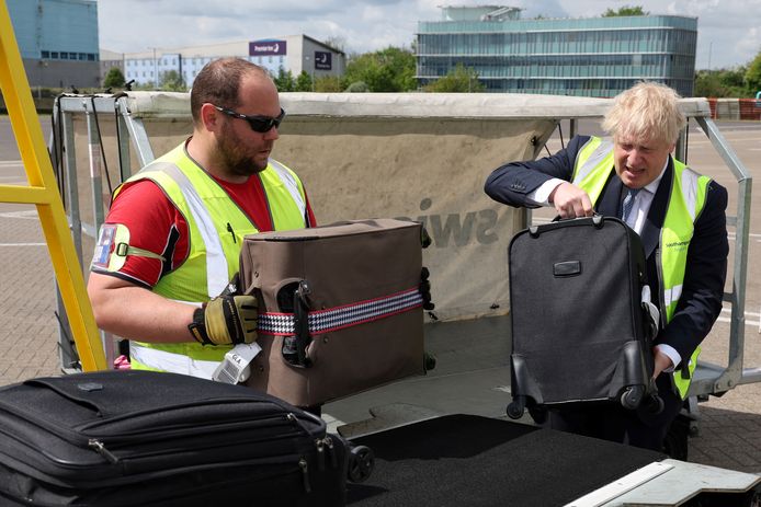 De Britse premier Boris Johnson helpt mee met het inladen van koffers in een vliegtuig op de luchthaven van Southampton.