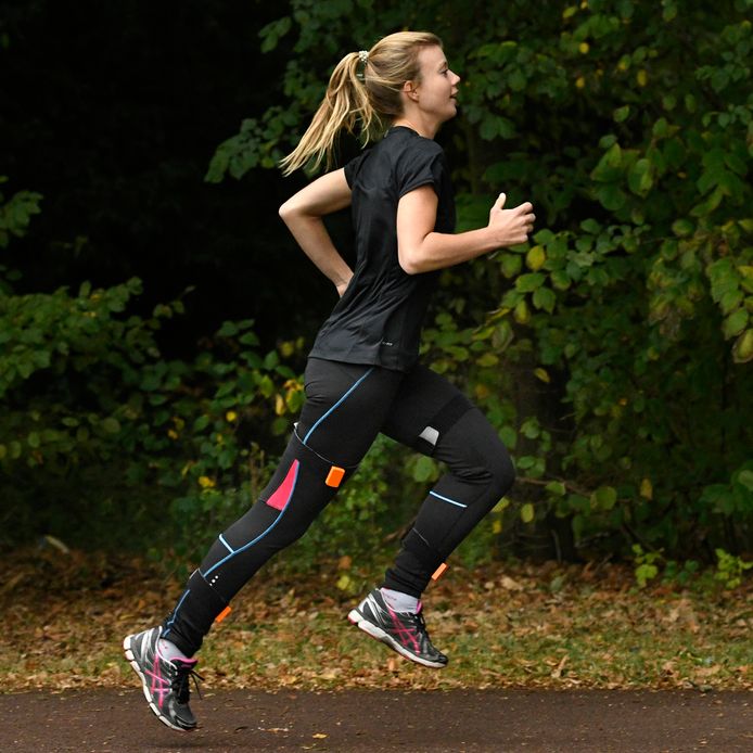 Hardloopster beplakt met sensoren. Via het sporthorloge of in de smartphone geplugde 'oortjes' geeft de Runner Assist advies.