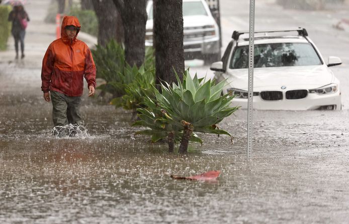 Een man loopt door zware regen in Santa Barbara, Californië.