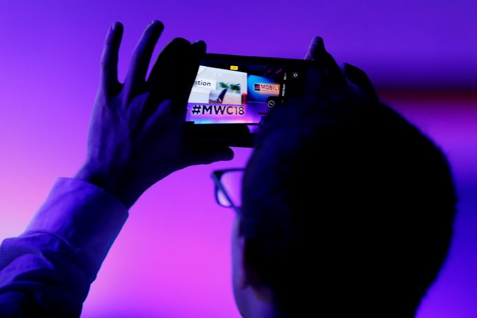 Iemand maakt een foto met zijn smartphone tijdens een persconferentie op de tweede dag van het Mobile World Congress in Barcelona, dat nog tot donderdag loopt.