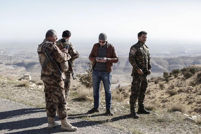 Remco Andersen spreekt met Koerdische Peshmerga terwijl hij wacht om Sinjar, Irak, binnen te gaan op 11 november 2015. Sinjar was een dag eerder ingenomen door IS. Beeld Sam Tarling