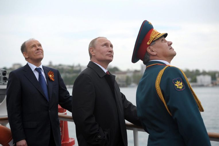 De Russische president Poetin (midden), Minister van Defensie Sergei Shoigu (rechts) en chef van de FSB Alexander Bortnikov (links) tijdens een militaire parade op de Krim, 2014. Beeld epa
