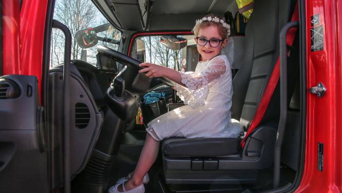 Communicantjes blinken in hun vel achter het stuur van de brandweerwagen