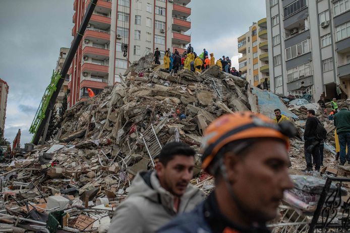 Reddingswerkers zoeken naar overlevenden onder het puin in de Turkse provincie Adana.