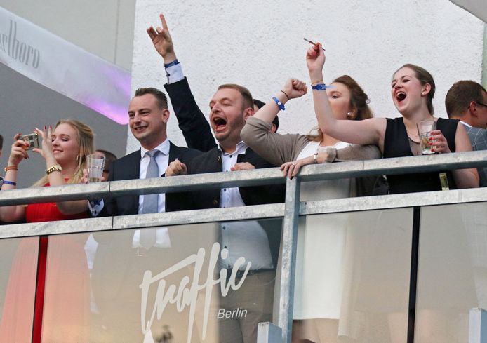 Aanhangers van AfD roepen vanaf het balkon van hun overwinningsfeestje naar demonstranten.