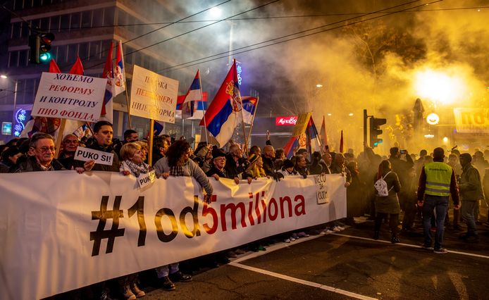 Demonstranten houden een spandoek omhoog dat zegt  ‘#1 van de 5 miljoen' tijdens een manifestatie in Belgrado.