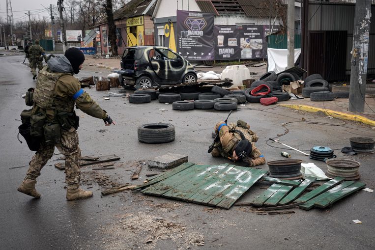 Oekraïense soldaten controleren voorwerpen in Boetsja op boobytraps. Beeld AP