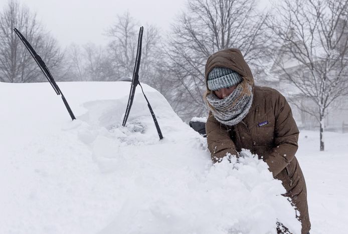 A woman tries to clear snow from her car in Buffalo, New York.