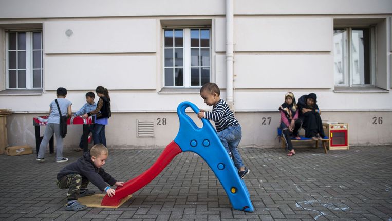 Kinderen spelen in het voormalige gemeentehuis van de Berlijnse wijk Wilmersdorf, dat nu als asielzoekerscentrum dient. Beeld afp