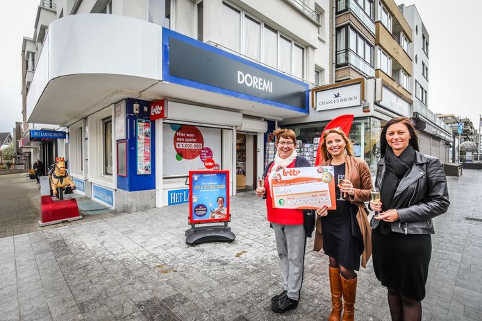 Patricia Desnoeck van dagbladhandel Do Re Mi neemt de cheque van de Nationale Loterij symbolisch in ontvangst.